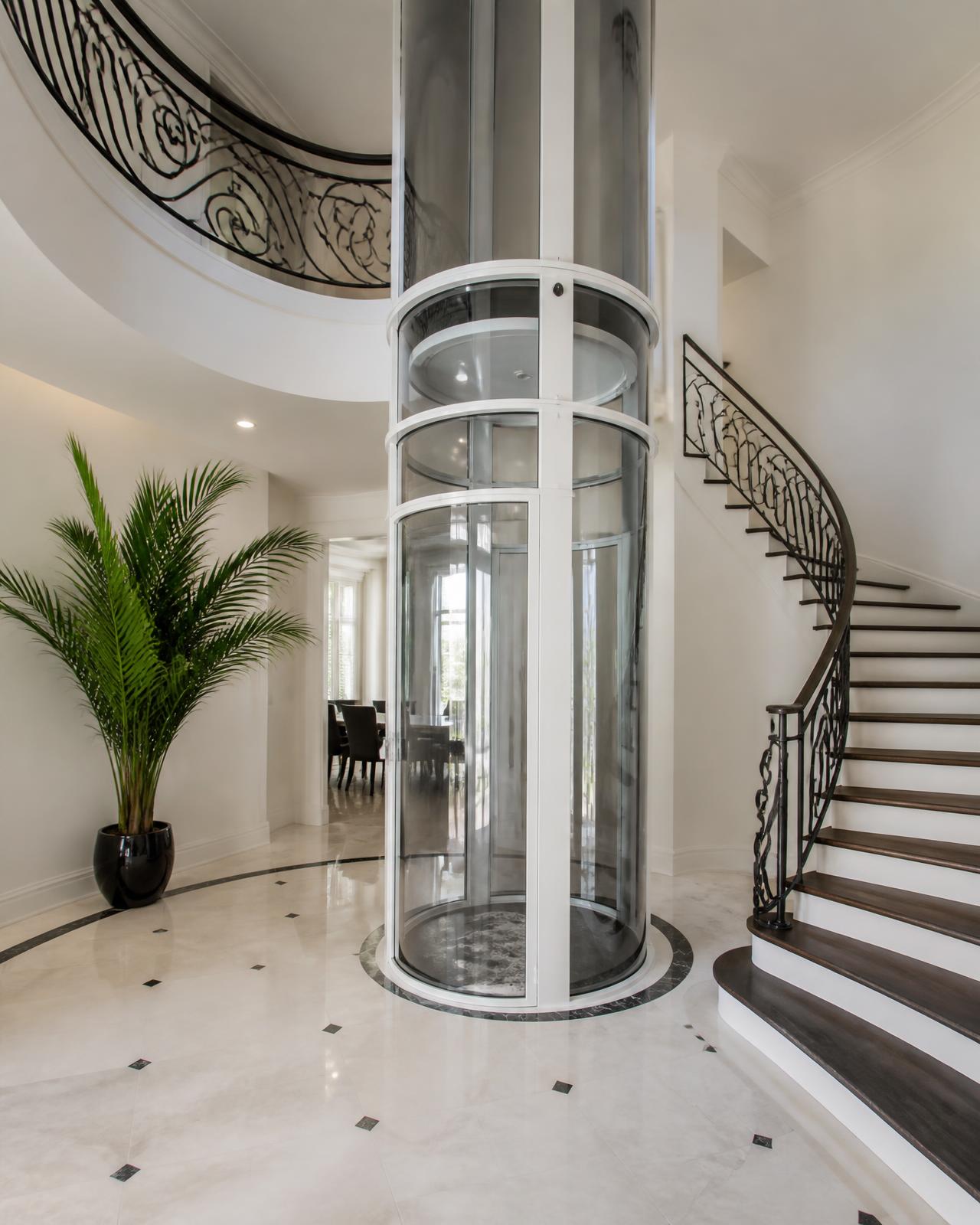 Vacuum lift glass tube in a villa foyer — pitless home lift